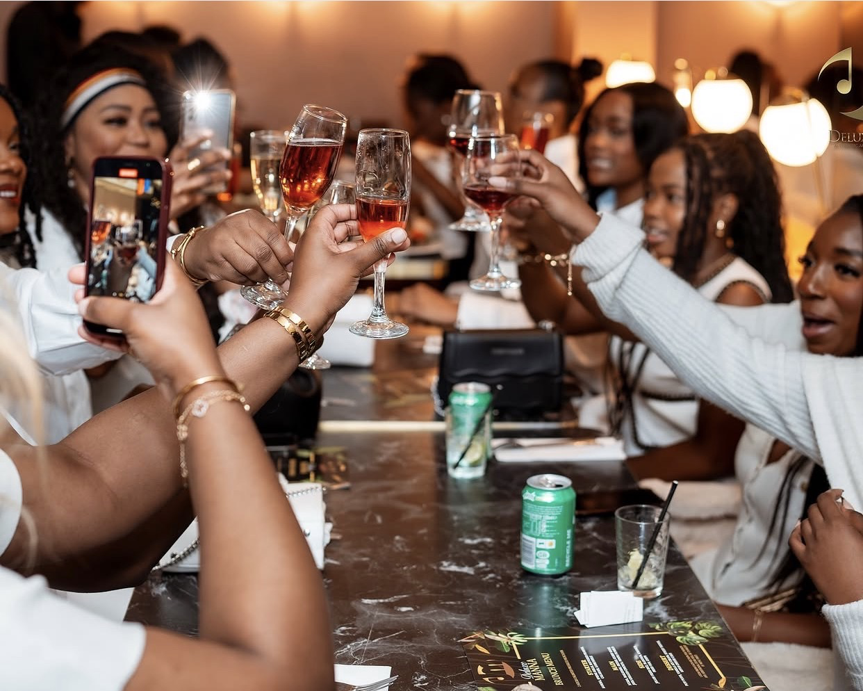 Friends raising their glasses together at Deluxe Manna